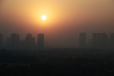 Silhouette buildings against sky during sunset