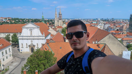 Young teen taking selfie with st. catherine's church, zagreb, croatia during a sunny day