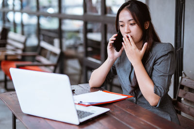 Young woman using laptop at table