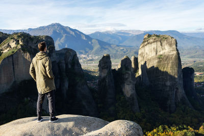 Man standing on rock against mountains