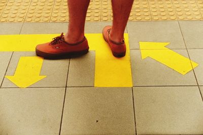 Low section of man standing on tiled floor