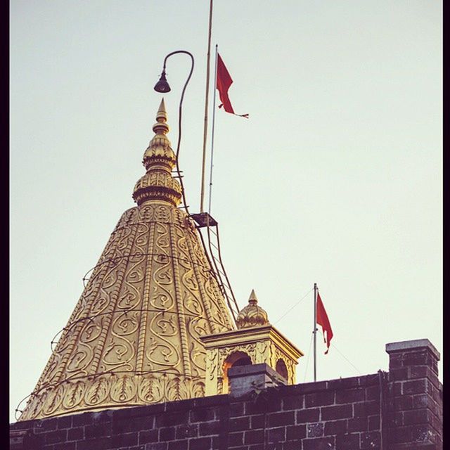 architecture, building exterior, built structure, low angle view, religion, place of worship, clear sky, spirituality, famous place, travel destinations, international landmark, sky, flag, capital cities, church, tourism, tower, high section, travel