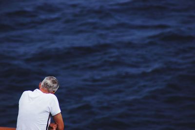 Rear view of man standing in sea