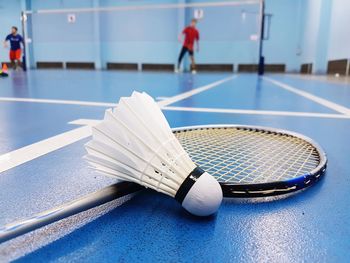 Close-up of badminton racket and shuttlecock on court