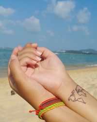 Female hands against sea in summer