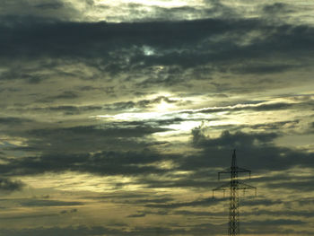 Silhouette electricity pylon against sky during sunset