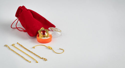 High angle view of red berries on table against white background