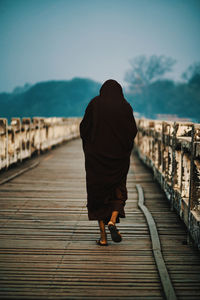 Rear view of woman walking on footpath