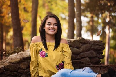 Portrait of smiling young woman in forest