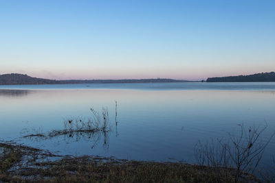 Scenic view of lake against clear blue sky