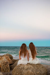 Rear view of woman looking at sea against clear sky