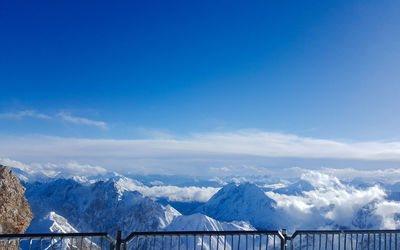 Scenic view of snowcapped mountains against blue sky