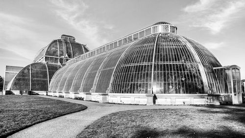 Low angle view of modern building against cloudy sky