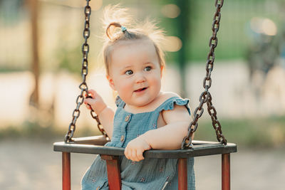 Portrait of boy swinging at playground