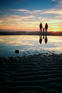 Family of three walking on beach