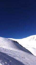 Scenic view of snowcapped mountains against clear blue sky