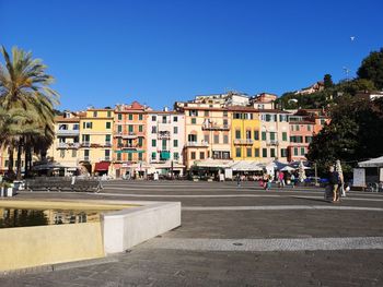 Buildings by road against sky in city