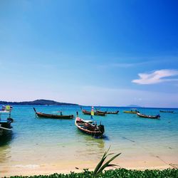 Boats moored on sea against sky