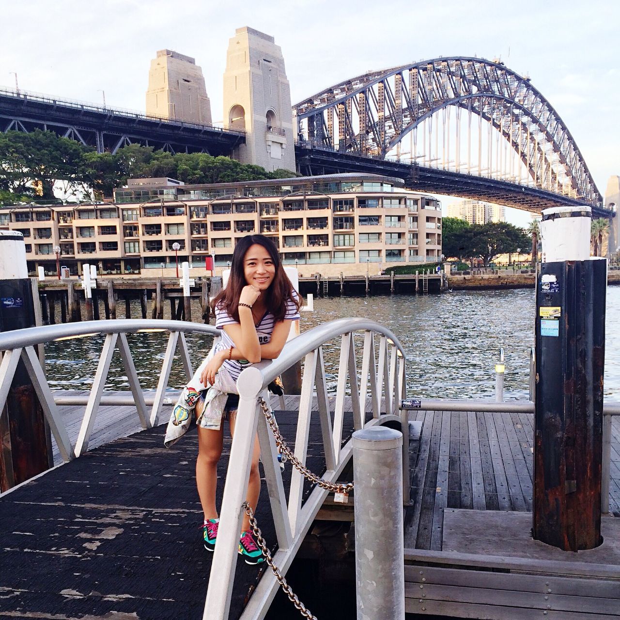 young adult, built structure, lifestyles, architecture, casual clothing, person, building exterior, leisure activity, standing, young women, water, looking at camera, portrait, front view, full length, river, sunglasses, railing