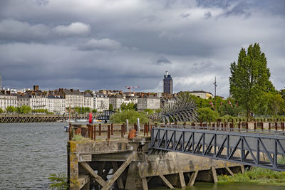 View of buildings in city against cloudy sky