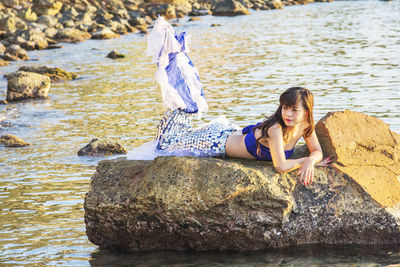 Portrait of young woman on rock