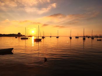 Silhouette sailboats in sea against sky during sunset