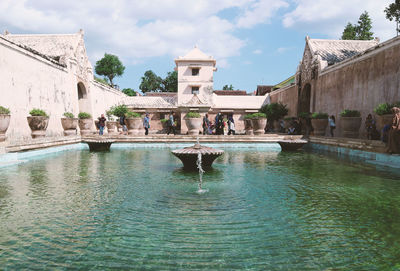 Fountain outside historic building against sky