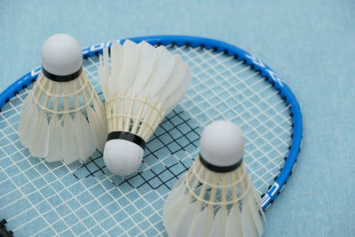 High angle view of shuttlecocks and badminton racket on table