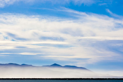 Scenic view of mountain range against cloudy sky