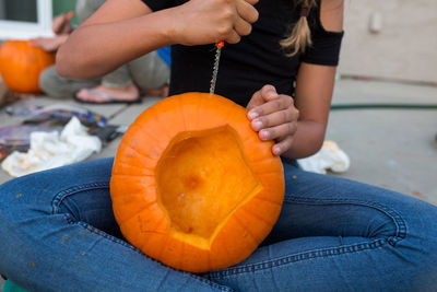 Inside view of carved pumpkin while girl carves the side