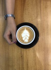 Woman holding coffee cup on table