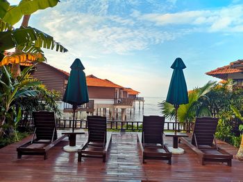 Chairs and tables against built structure against sky