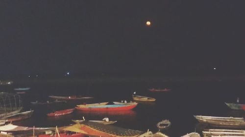 Illuminated lights on table against sky at night