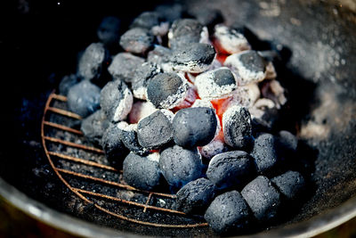 Closeup of glowing coal in metal grill on summer day in the garden