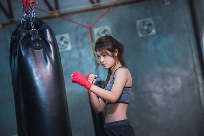 Side view of female boxer punching bag