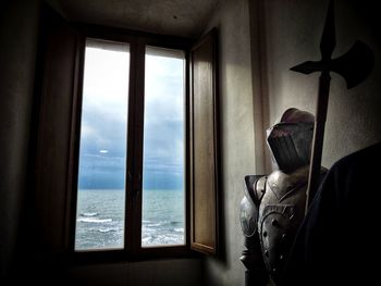 Close-up of man by window against sea