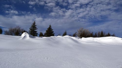 Snow covered landscape against sky