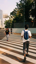 Rear view of people crossing road