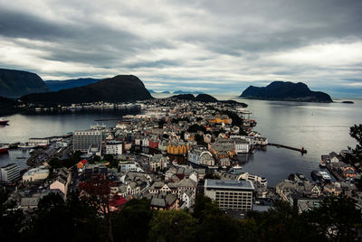 High angle view of cityscape by sea against sky