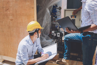 Low angle view of man working with mobile phone