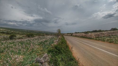 High angle view of road on landscape against storm clouds