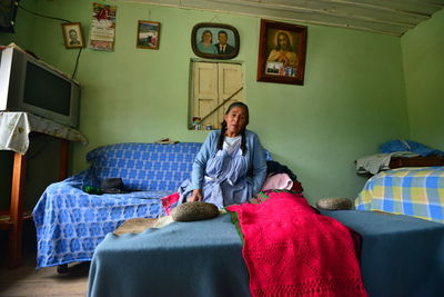 Portrait of woman sitting on bed at home