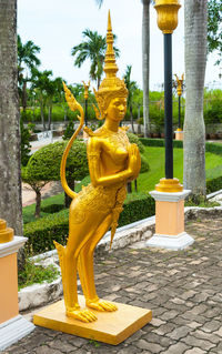 Yellow statue against trees