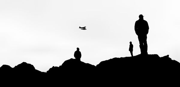 Silhouette people standing against clear sky