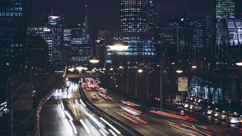 High angle view of light trails on city street amidst buildings