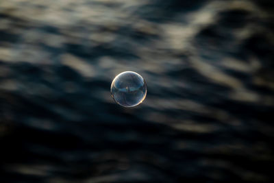 Close-up of bubbles in sea against sky