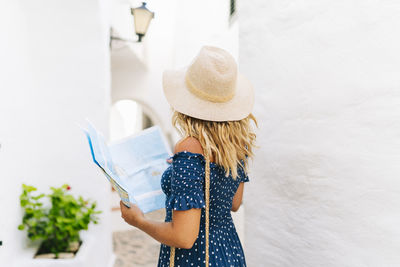 Rear view of a girl holding hat