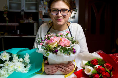 Smiling florist woman with three different bouquets of flowers. portrait of young female florist 