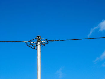 Low angle view of pole against blue sky