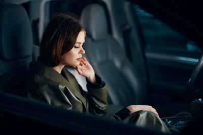 Young woman sitting in car